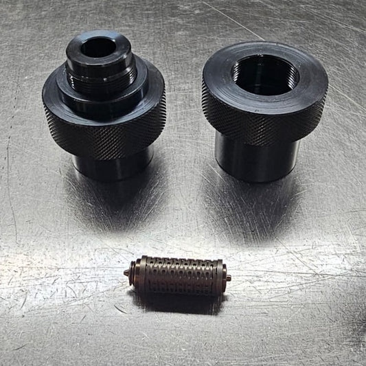 Three black mechanical components on a metallic surface
